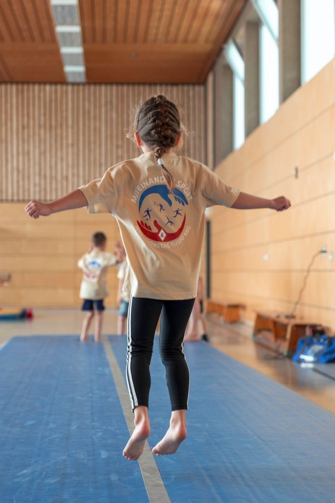 Kind in einer Turnhalle beim Sport